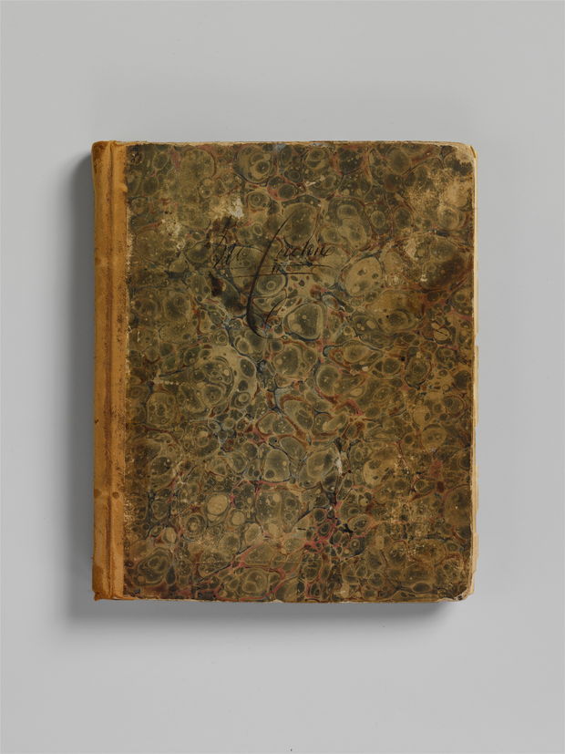 Photograph of a small bound account book from the eighteen-thirties, its marbled paper boards rubbed through at the corners and its leather spine worn pale.